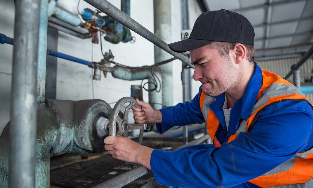 worker turning valve in factory